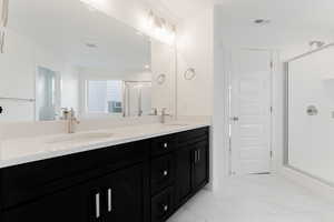 Bathroom with vanity and a shower with shower door