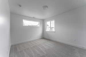 Unfurnished room featuring a textured ceiling and light colored carpet