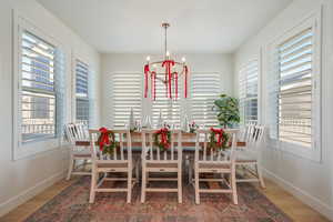 Dining space with a chandelier, wood-type flooring, and plenty of natural light