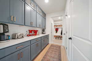 Kitchen with light hardwood / wood-style floors and tasteful backsplash