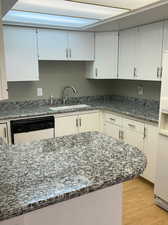 Features granite counters, white cabinetry, white appliances, and pergo flooring.