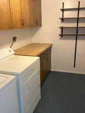 Features cabinets, and washer and clothes dryer