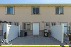 Back of property with cooling unit and a patio area