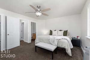 Bedroom featuring ensuite bathroom, ceiling fan, and dark carpet