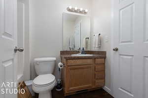 Bathroom with vanity, toilet, and wood-type flooring