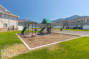 View of jungle gym with a yard and a mountain view