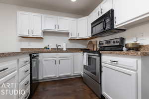 Kitchen featuring white cabinets, dark hardwood / wood-style floors, stainless steel range with electric cooktop, and sink