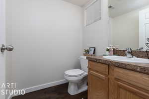 Bathroom featuring hardwood / wood-style flooring, toilet, and vanity