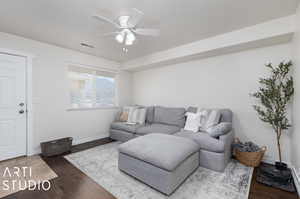 Living room with ceiling fan and dark hardwood / wood-style floors