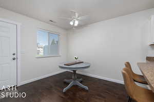 Unfurnished office featuring ceiling fan and dark wood-type flooring