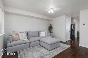 Living room featuring ceiling fan and dark hardwood / wood-style flooring