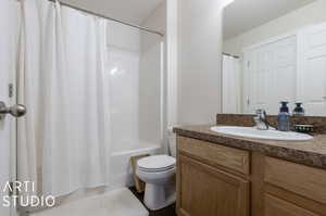 Full bathroom with vanity, shower / tub combo, and toilet