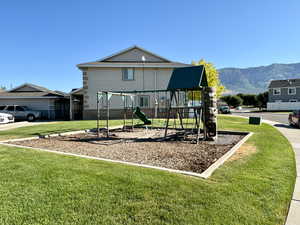 View of play area with a lawn and a mountain view