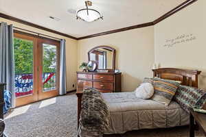 Carpeted bedroom featuring access to outside and ornamental molding