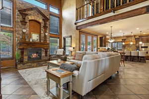 Tiled living room with a fireplace and a high ceiling