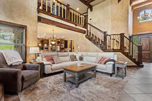 Tiled living room with a chandelier and a high ceiling