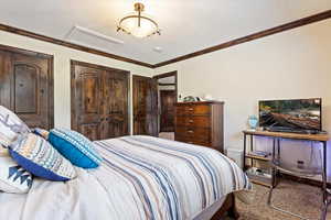 Carpeted bedroom featuring ornamental molding