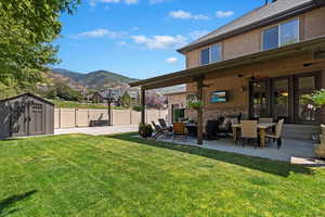 View of yard featuring an outdoor living space, a storage shed, a mountain view, a patio, and ceiling fan