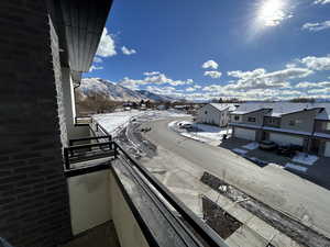 Snow covered back of property with a mountain view