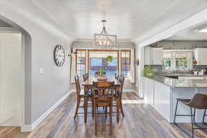 Dining space with a notable chandelier, sink, crown molding