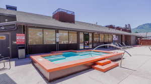 View of swimming pool with a mountain view, a patio, and a hot tub