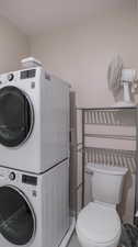 Clothes washing area featuring stacked washer and dryer