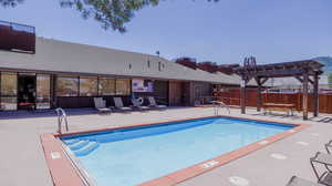 View of swimming pool with a pergola and a patio