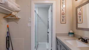 Bathroom featuring vanity, tile patterned floors, and an enclosed shower