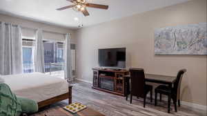 Bedroom with access to outside, ceiling fan, and wood-type flooring