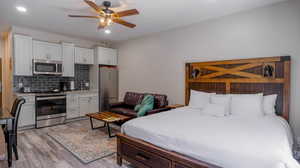 Bedroom featuring ceiling fan, sink, stainless steel refrigerator, and light hardwood / wood-style floors