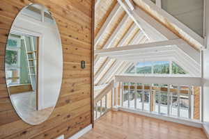 Additional living space with beam ceiling, wood ceiling, hardwood / wood-style floors, and high vaulted ceiling