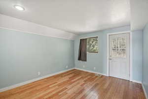 Entryway with light hardwood / wood-style flooring and lofted ceiling