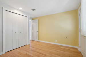 Unfurnished bedroom featuring a closet and light wood-type flooring