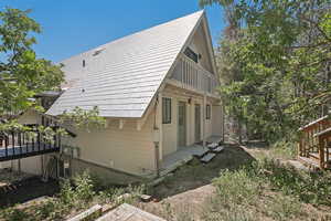 View of property exterior with a wooden deck