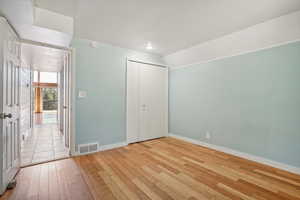 Unfurnished bedroom with light hardwood / wood-style flooring and a closet