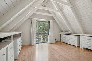 Bonus room with light hardwood / wood-style floors and lofted ceiling with beams