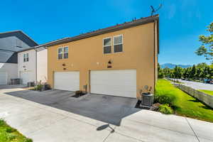 View of side of property featuring cooling unit, a garage, and a mountain view