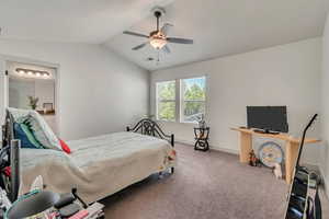 Carpeted bedroom with vaulted ceiling and ceiling fan