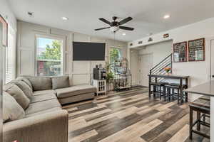 Living room with hardwood / wood-style floors, a wealth of natural light, and ceiling fan