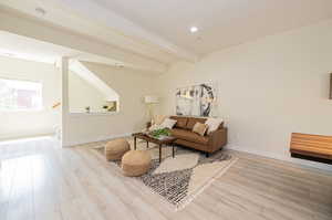 Living room featuring beam ceiling and light wood-type flooring