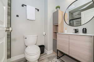 Bathroom with wood-type flooring, toilet, and vanity