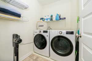 Laundry room featuring light tile patterned flooring and independent washer and dryer