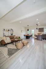 Living room featuring beamed ceiling and light hardwood / wood-style floors