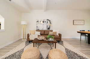 Living room featuring light hardwood / wood-style floors and beam ceiling