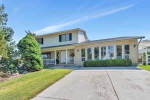 View of front of house with covered porch and a front lawn