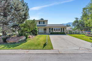 View of front property with a porch and a front yard