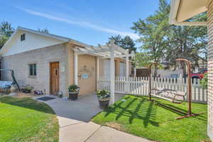 View of front of property featuring a pergola, a patio, and a front lawn