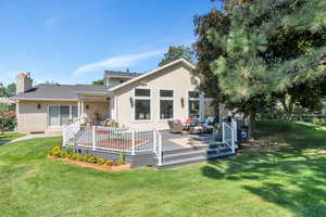 Back of house with a lawn, an outdoor living space, and a wooden deck