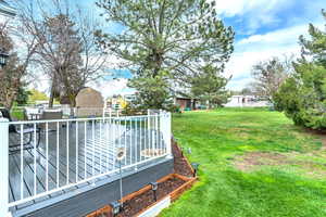 View of yard featuring a storage shed and a deck