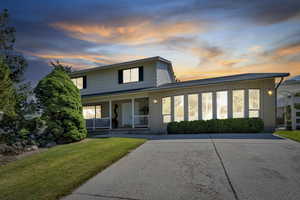 View of front of house featuring covered porch and a yard